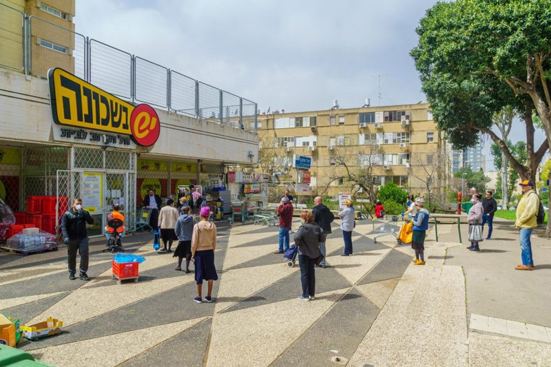 People follow the social distancing rules while waiting outside a supermarket in Haifa, Israel. March 2020.