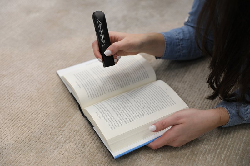 OrCam Read is a lightweight, handheld device with a smart camera that seamlessly reads text from any printed surface or digital screen.