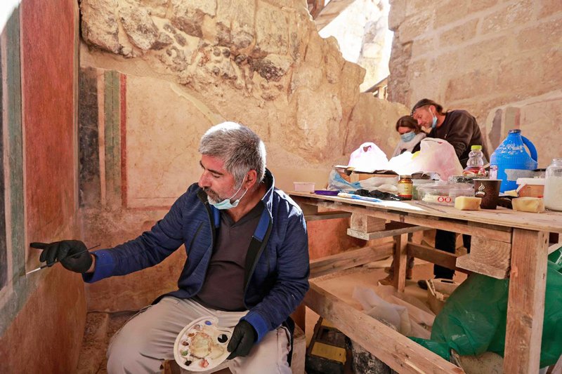 Mark Avrahami (L), a conservator of the Israel Antiquities Authority, restores ancient frescoes at the arches corridor leading to the Herodium palace built by Herod the Great in 23-15 BCE in the Judaean desert, southeast of Bethlehem in the West Bank, on November 22, 2020.