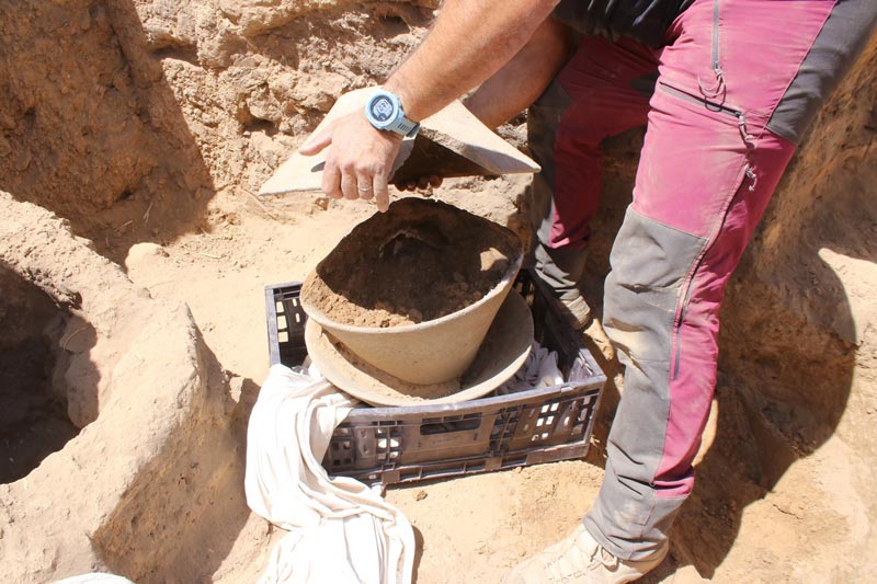 The broken ivory vessel deposited within the large basalt bowls.